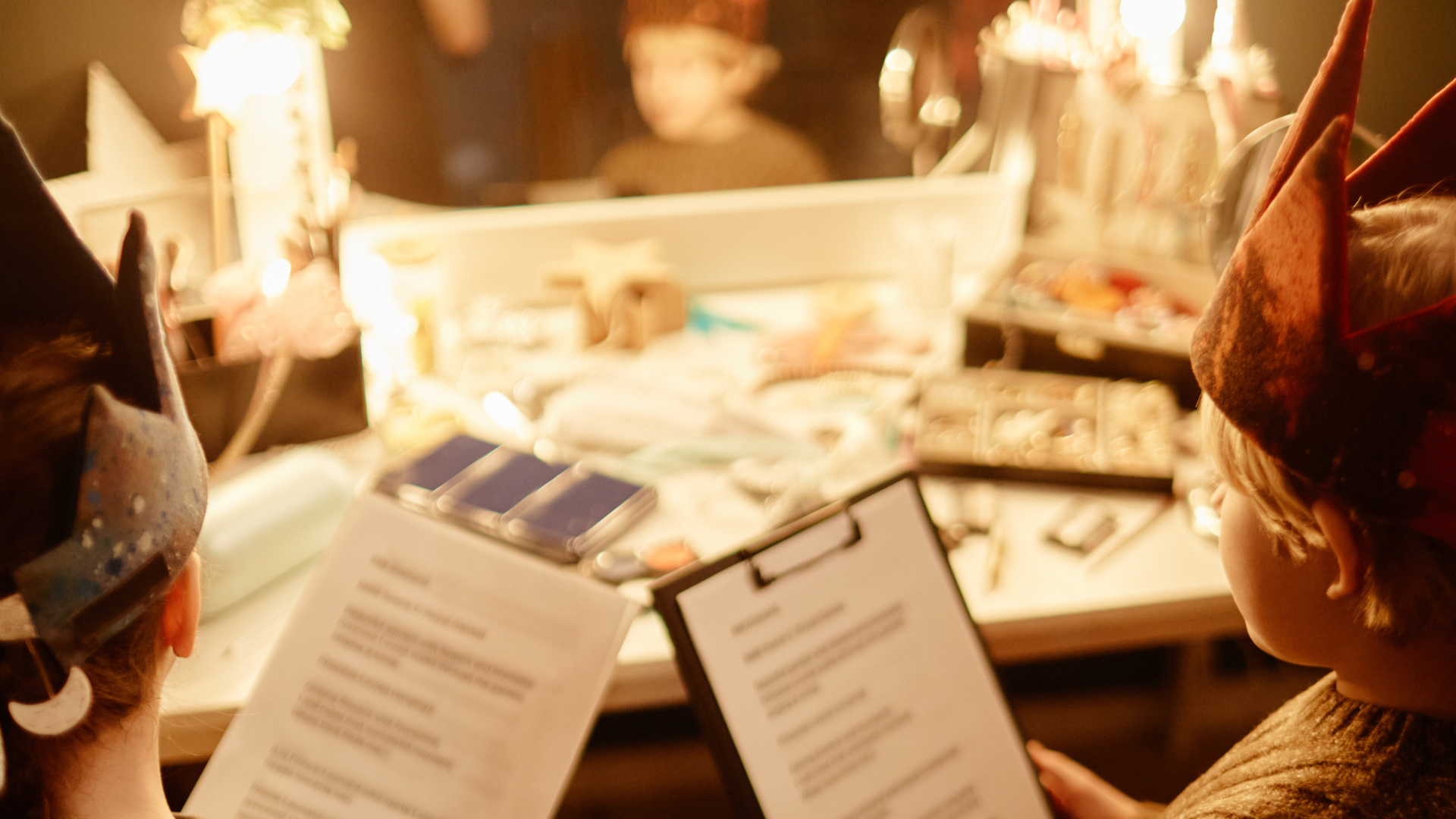 A costume rack in a dim studio corner, warm gold light spilling from a single overhead lamp, a clipboard hanging from one hanger.